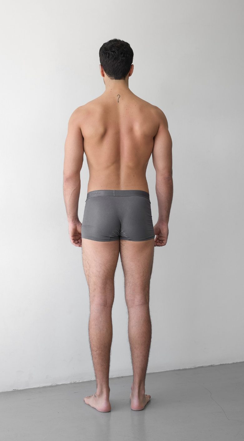Full-body digital of a male model, back view, head to toe against a plain wall