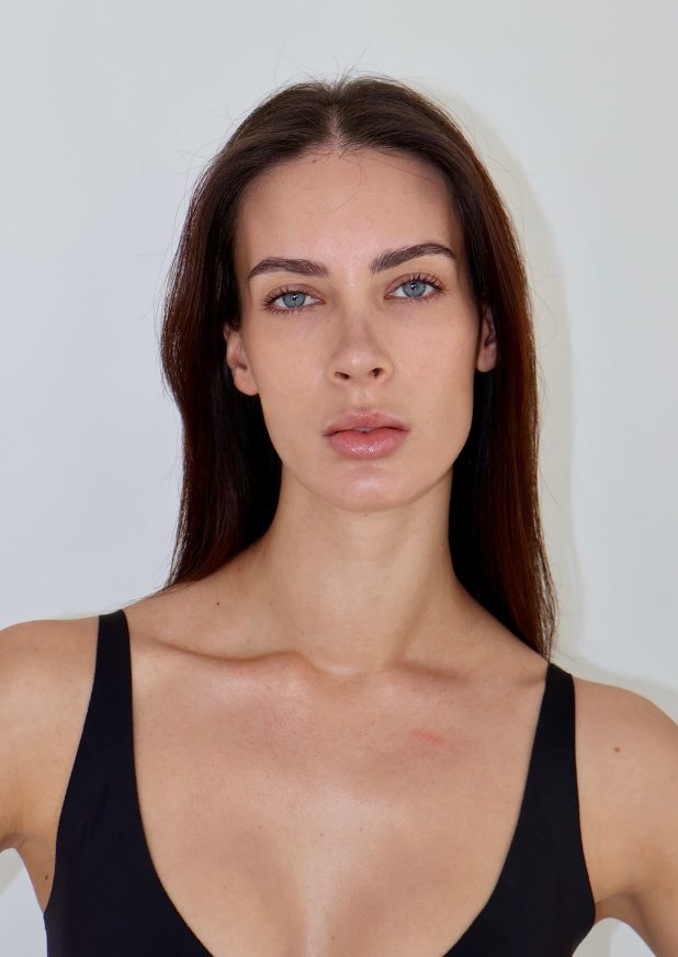 Example digital of a female model: natural light, plain background, no filters