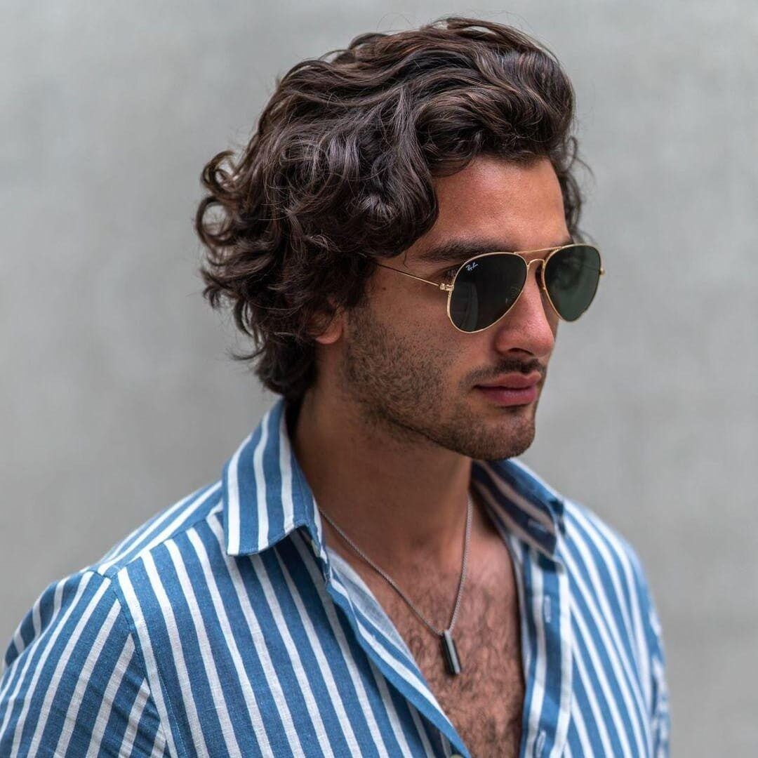 Mannequin homme aux cheveux bruns ondulés, lunettes aviateur et chemise rayée bleue – Emporio Models Marrakech